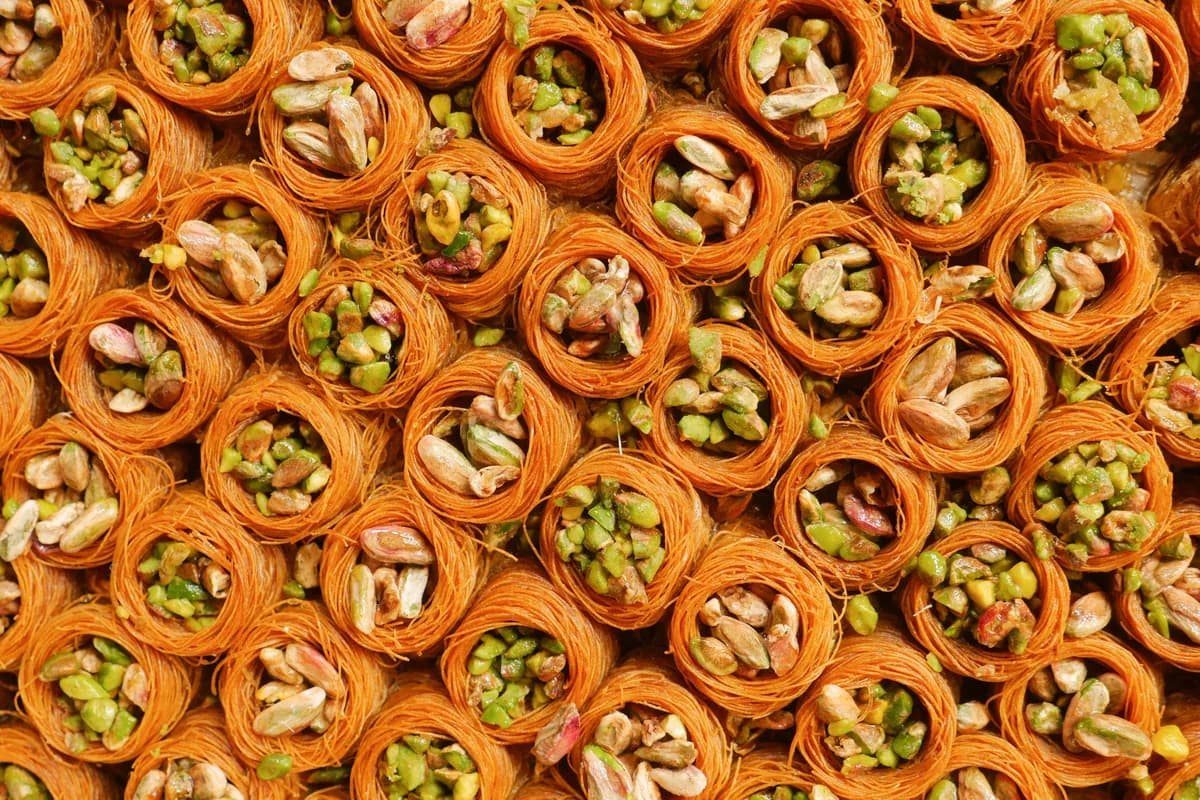 Rolled pistachio baklava packed tightly on a serving tray