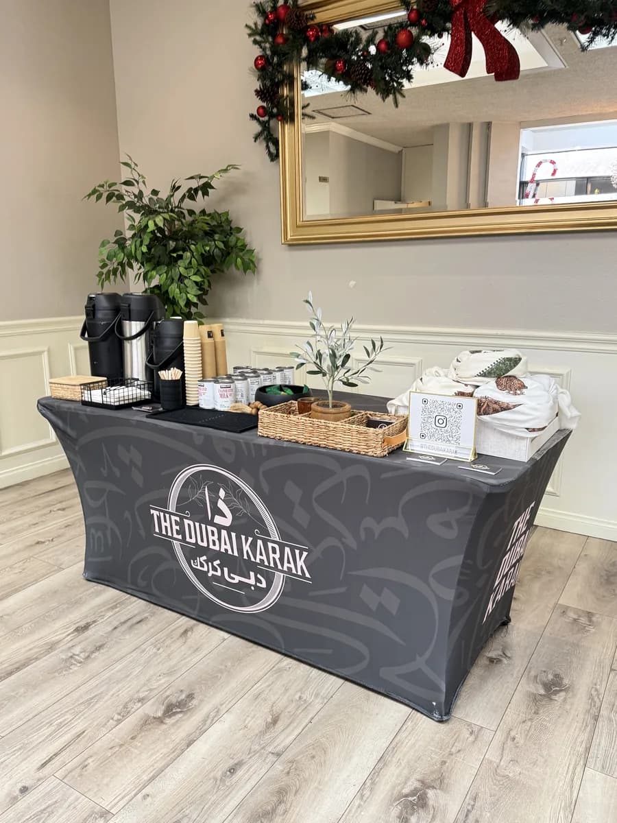 The Dubai Karak black branded table set up indoors with brewing equipment and cups