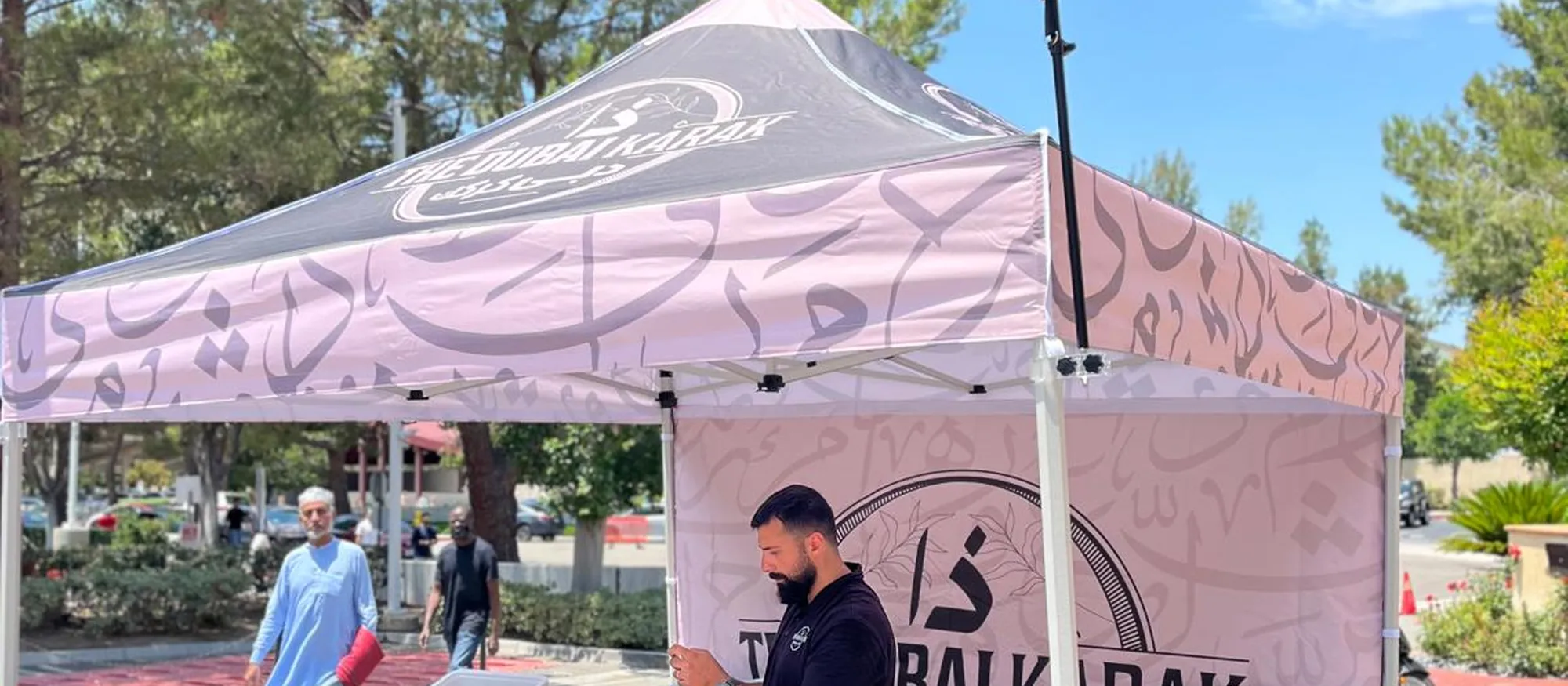 The Dubai Karak canopy booth set up at an outdoor market with staff serving guests