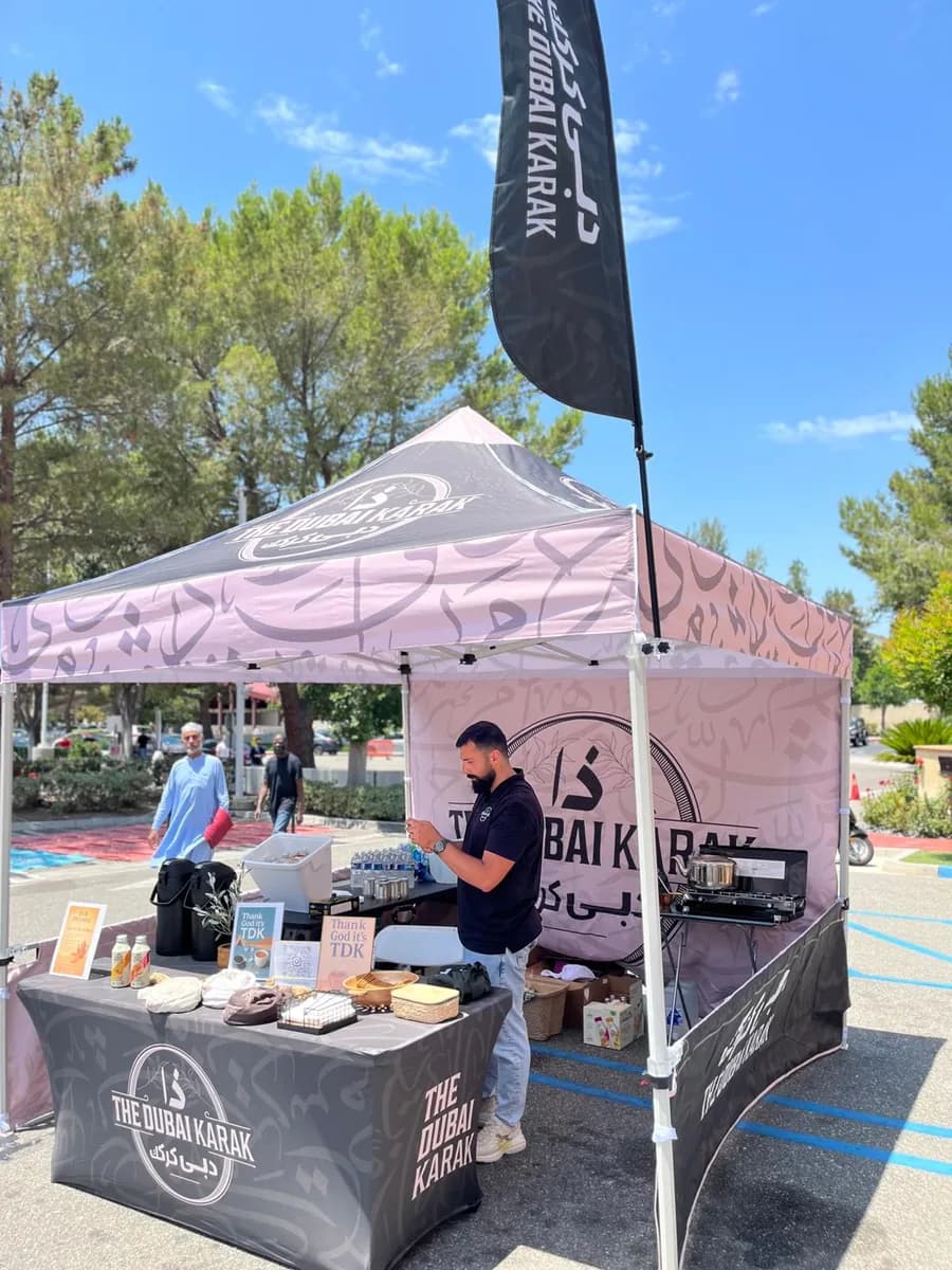 The Dubai Karak canopy booth set up at an outdoor market with staff serving guests