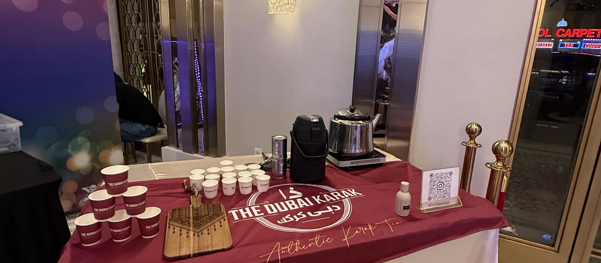 The Dubai Karak branded table laid with cups and serving equipment at a formal venue