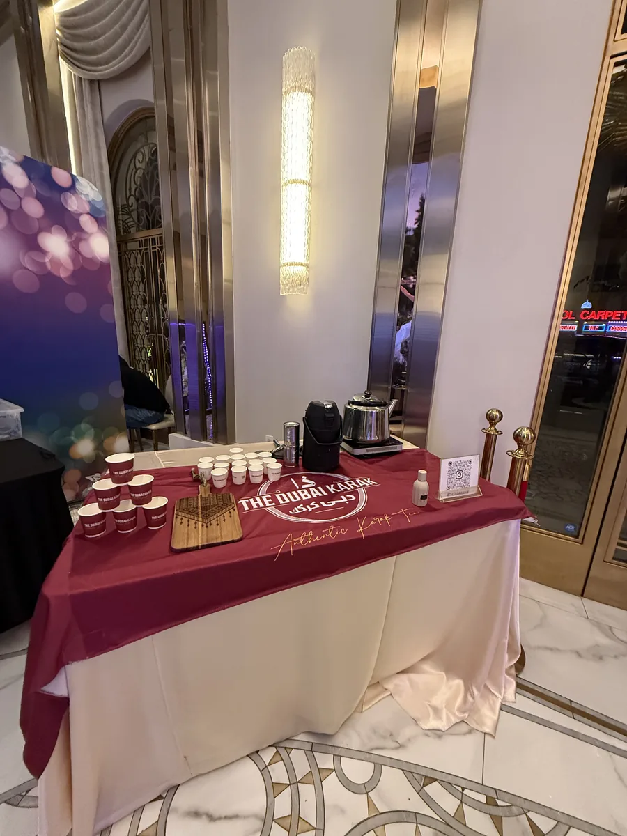 The Dubai Karak branded table laid with cups and serving equipment at a formal venue