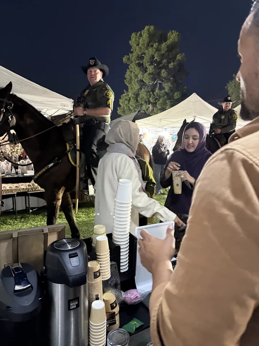 Guests collecting karak chai at an evening outdoor community event